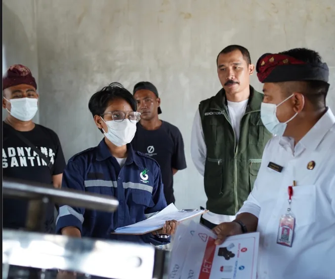 A COCO pyrolysis operator reviewing plastic sorting records with village officials at the Cepaka Learning Center